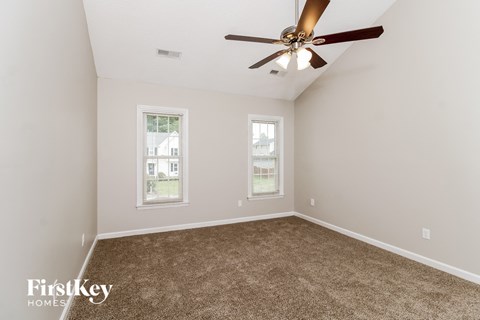 a bedroom with carpet and a ceiling fan