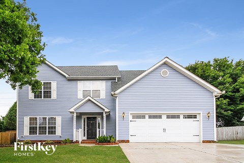 A blue house with a white garage door and a black door.