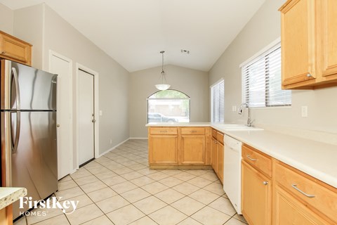 A kitchen with wooden cabinets and a stainless steel refrigerator.