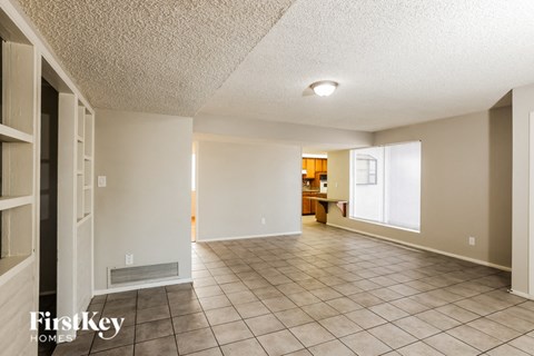 A spacious room with tile flooring and a ceiling light.