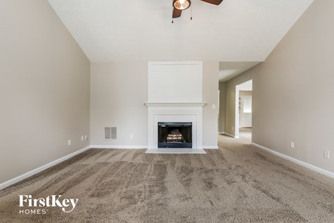 the living room has a fireplace and carpeted flooring