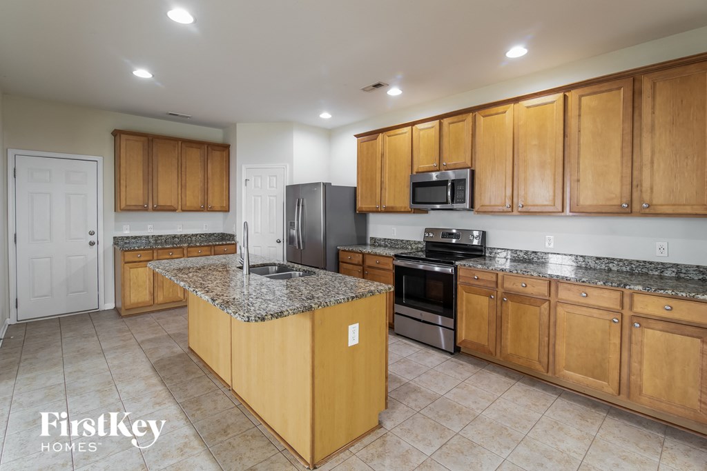 A kitchen with wooden cabinets and a granite countertop.