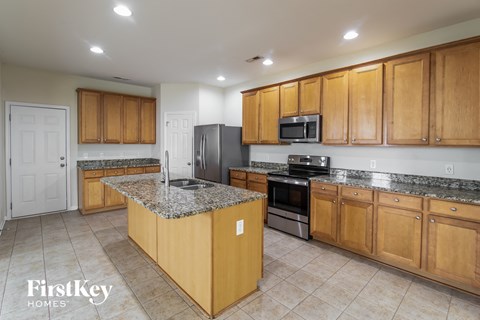 A kitchen with wooden cabinets and a granite countertop.