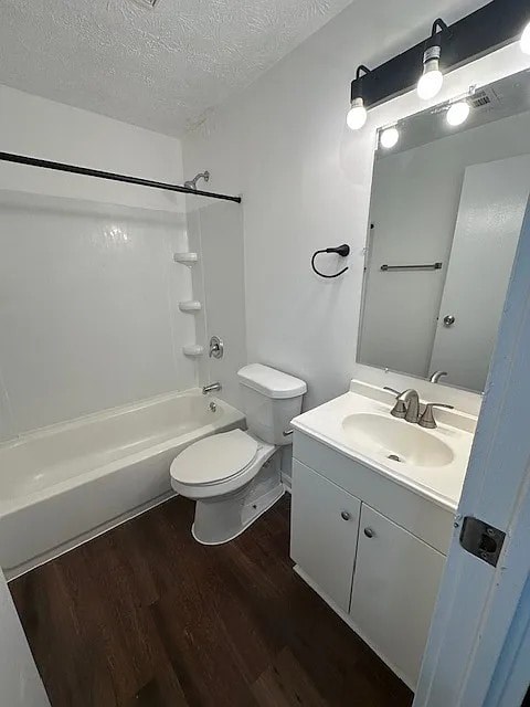 A white toilet sits next to a white sink in a small bathroom.