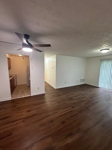 A room with a ceiling fan and wooden flooring.
