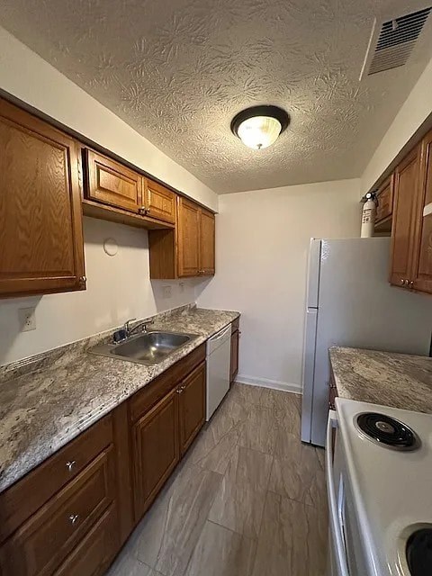 A kitchen with a white refrigerator and brown cabinets.