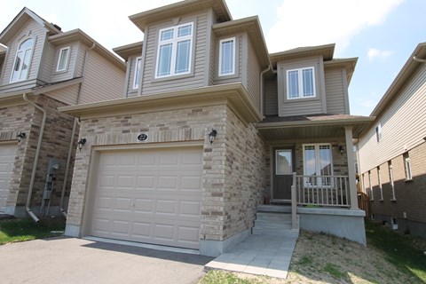 a tan brick house with a white garage door