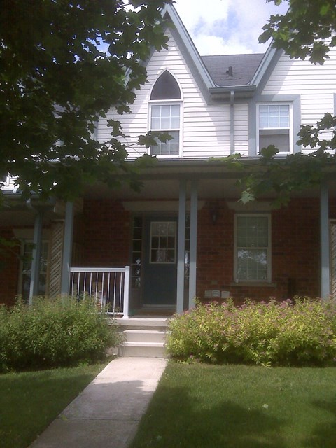 a house with a porch and a walkway in front of it