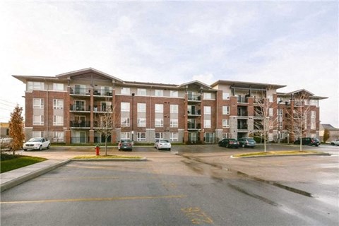 A large apartment complex with a parking lot in front.