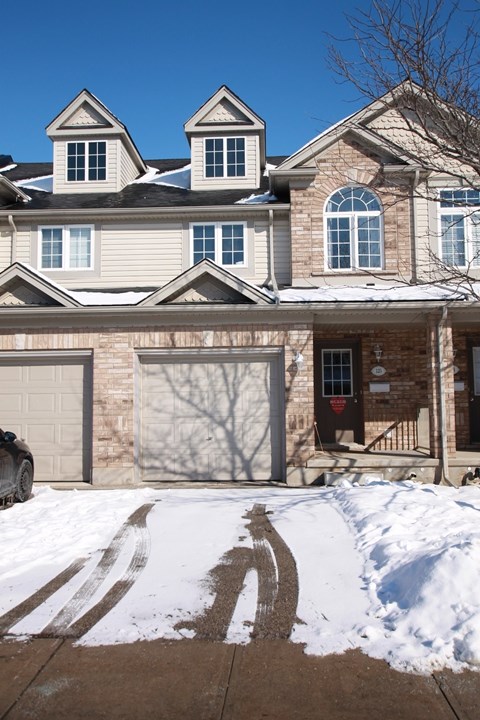 A house with a garage and a driveway covered in snow.
