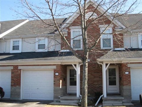 a brick house with a tree in front of it