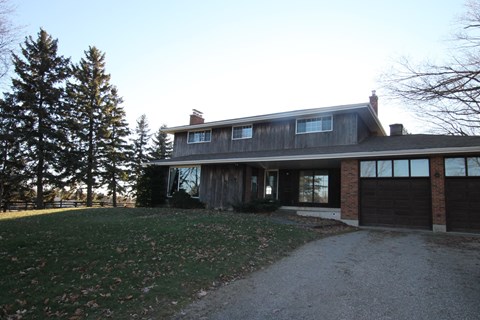 A house with a garage and a driveway in front of it.