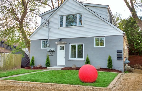 a large red rock in front of a house