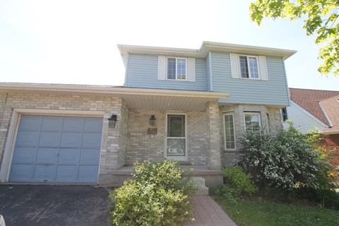 A house with a blue garage door and a brick wall.
