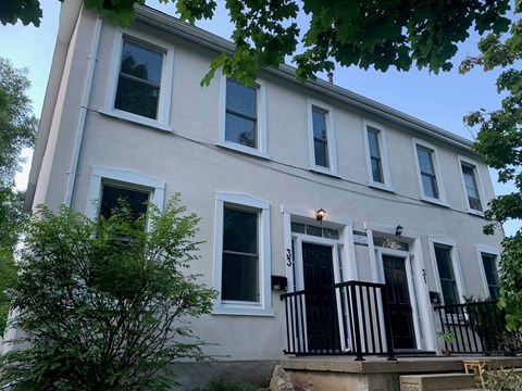A white house with black railings and a black door.