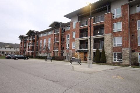 an apartment building on the corner of a street with benches