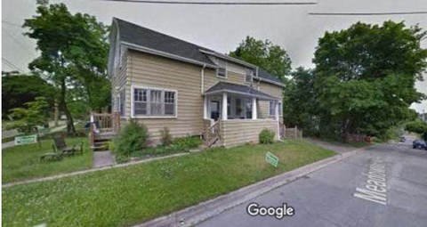 A house with a green sign in front of it.