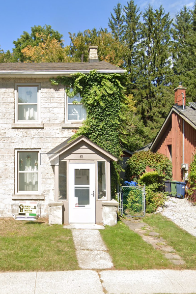 A white house with a grey door and a small porch.