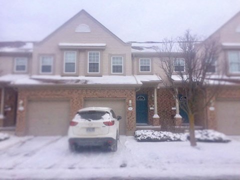 a car parked in the snow in front of a house