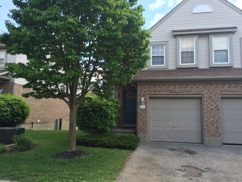 a house with a garage and a tree in front of it