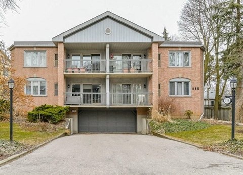 A two-story brick house with a balcony on the second floor.