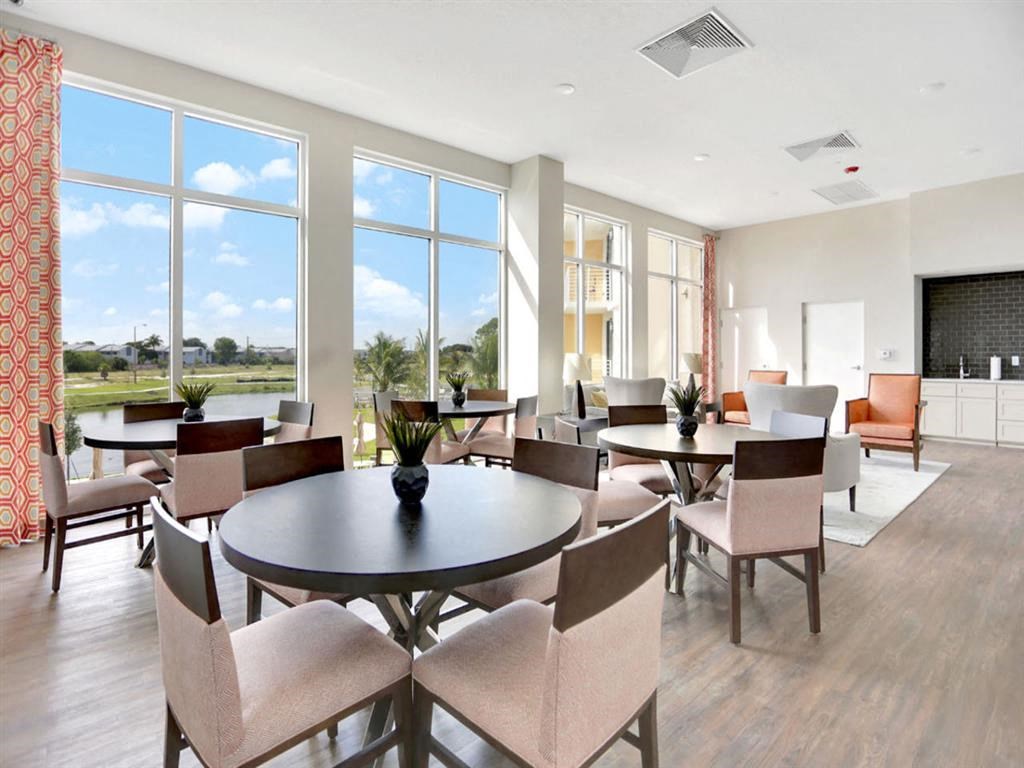 a dining room with tables and chairs and large windows