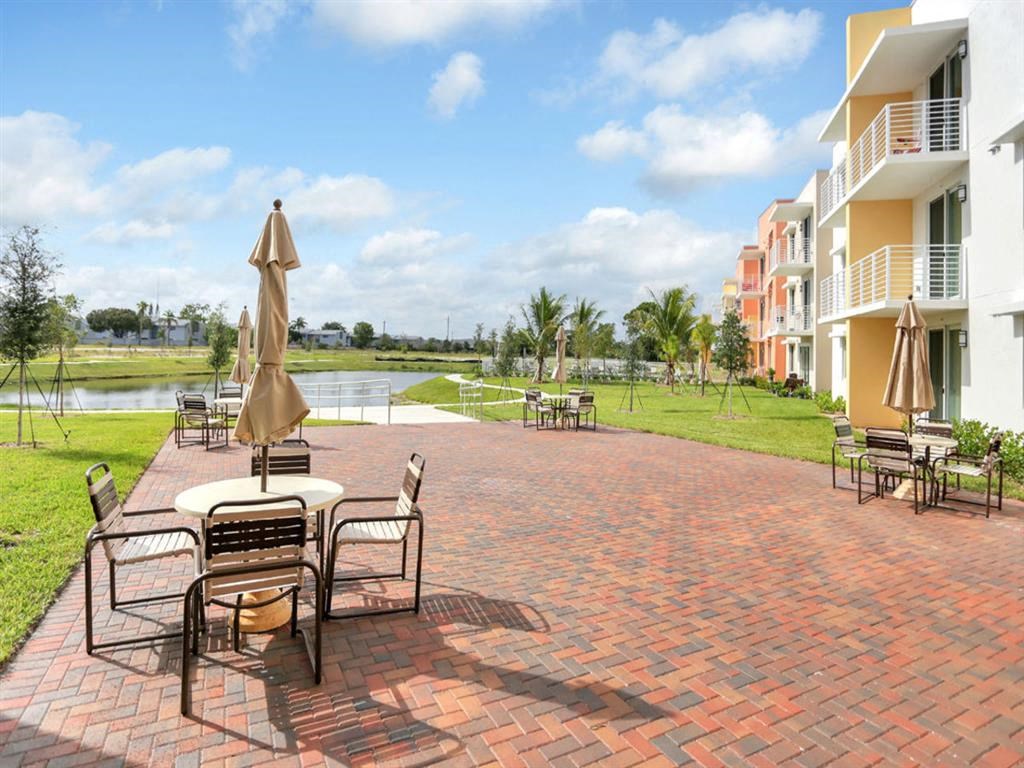 a patio with tables and umbrellas in front of a building