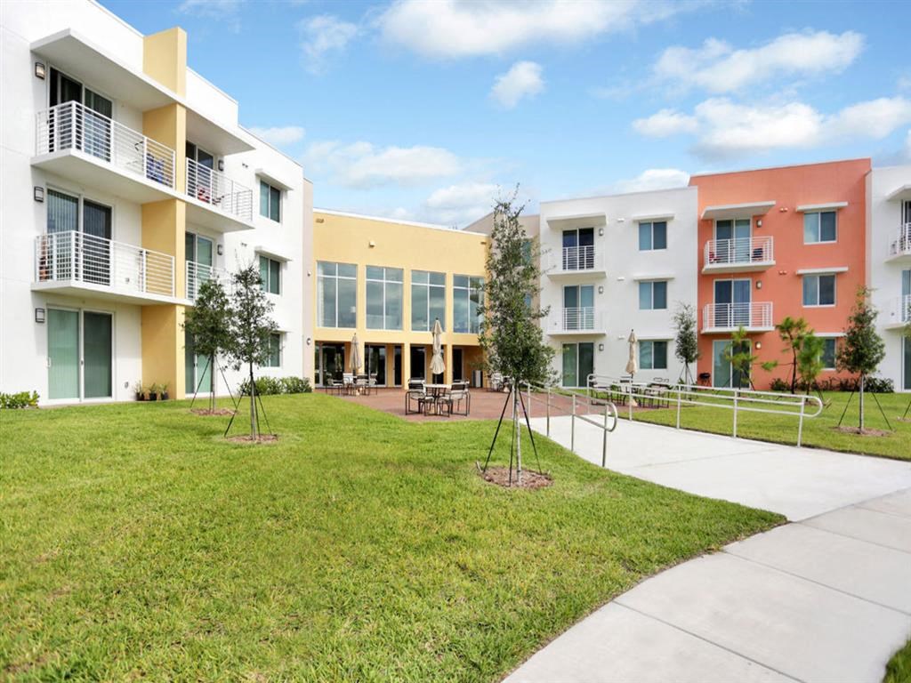 a grassy courtyard in front of an apartment building