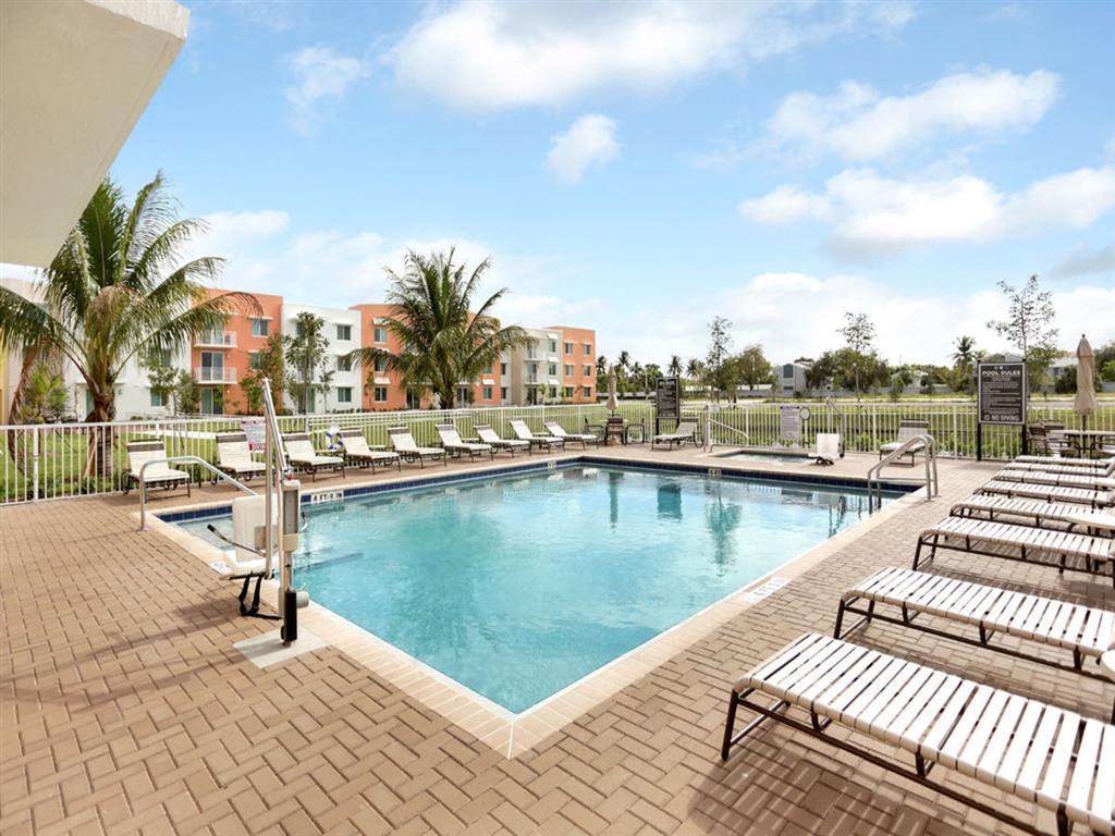 a swimming pool with benches and chairs at a resort