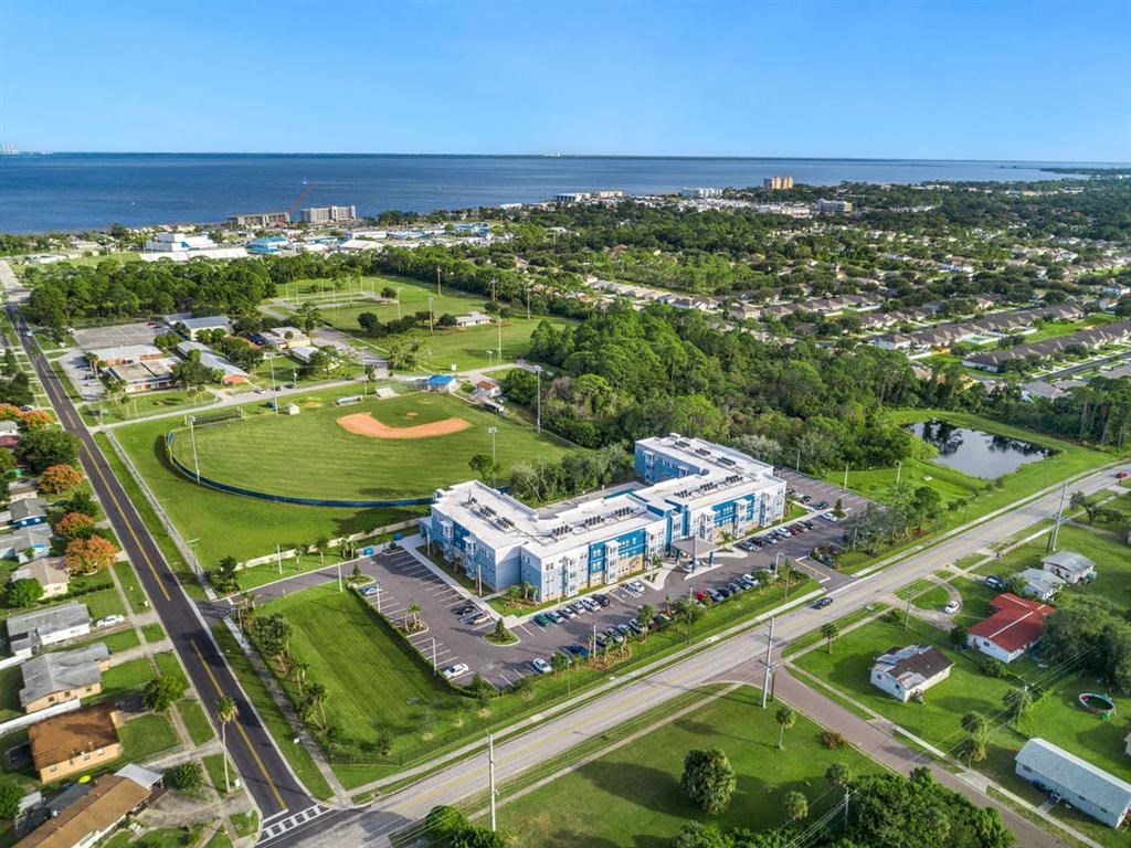 an aerial view of an apartment complex with the ocean in the background