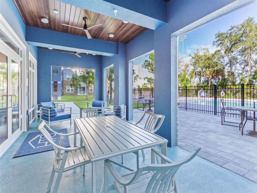 a patio with a table and chairs and a pool