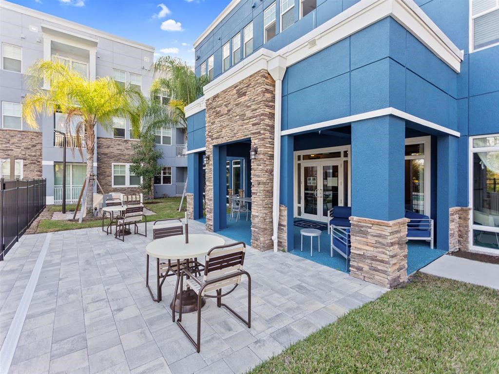 a patio with a table and chairs in front of a building