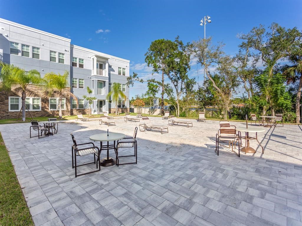 a patio with tables and chairs in front of a building