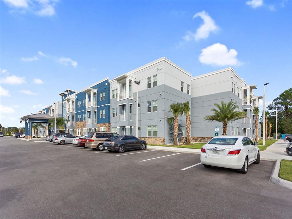 a parking lot with cars in front of an apartment building