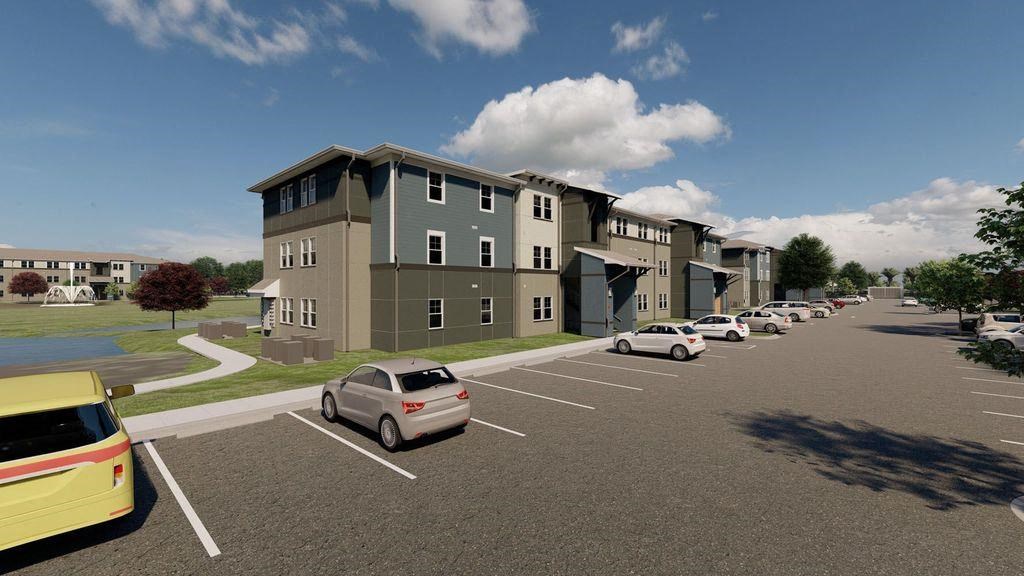 a parking lot with cars in front of an apartment building