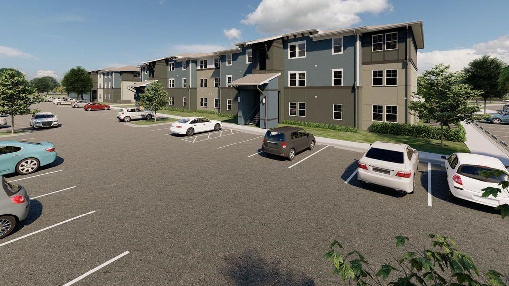 a parking lot with cars in front of an apartment building