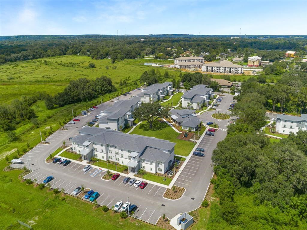 an aerial view of a parking lot with several houses and a field