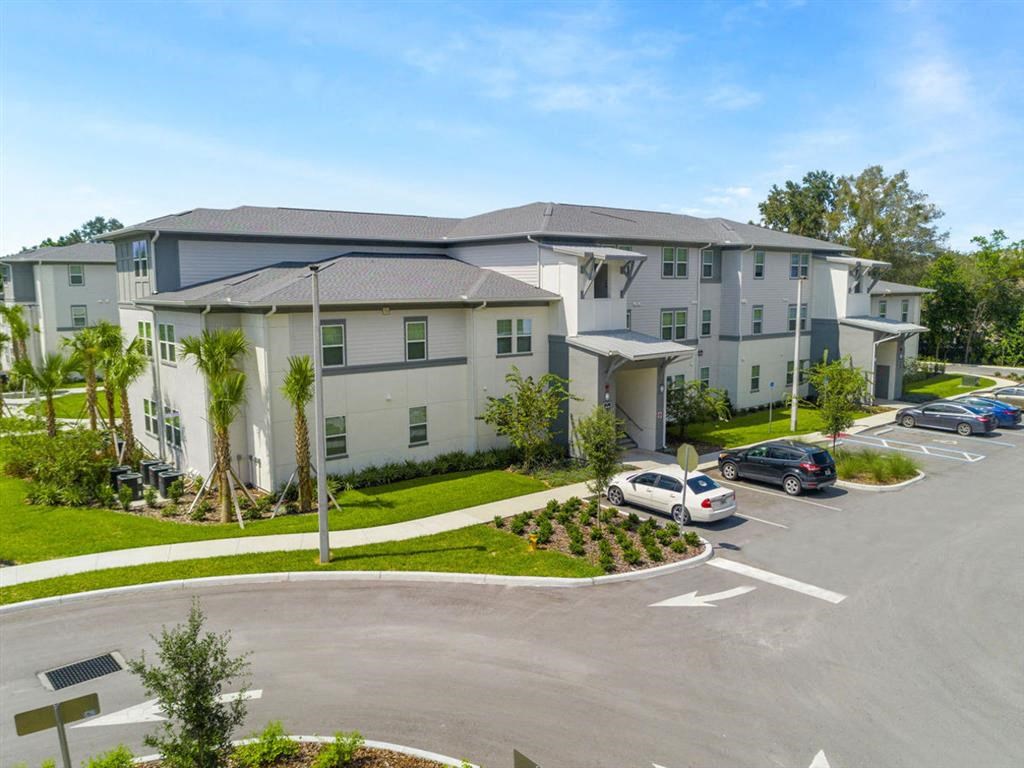 a large apartment building with cars parked in a parking lot