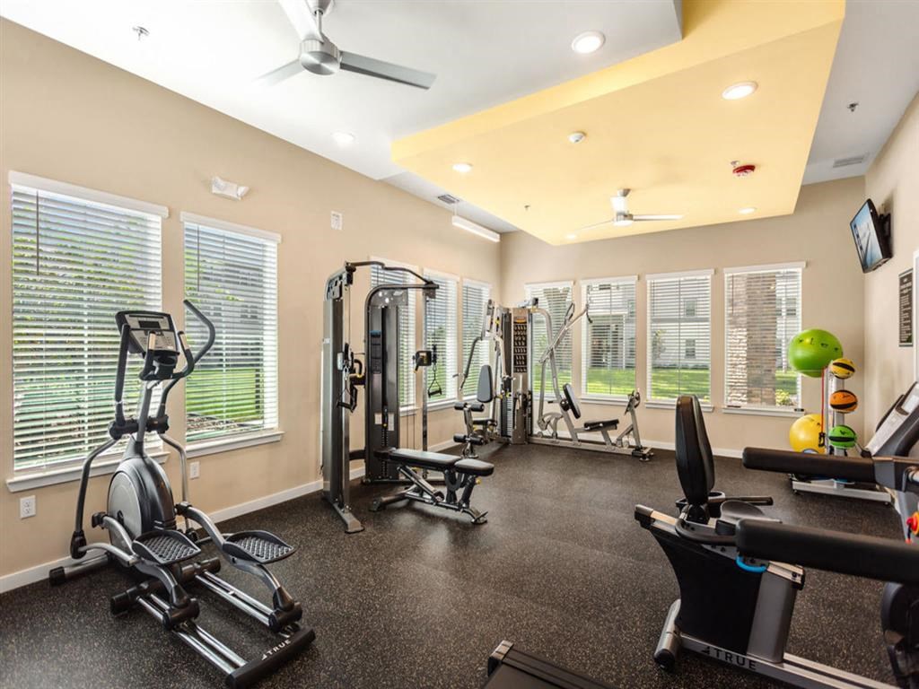 a home gym with exercise equipment and windows