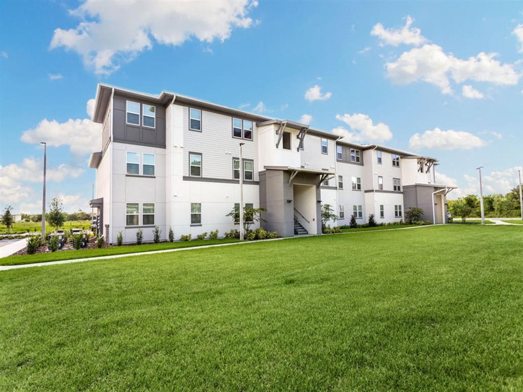 an image of an apartment building on a green lawn