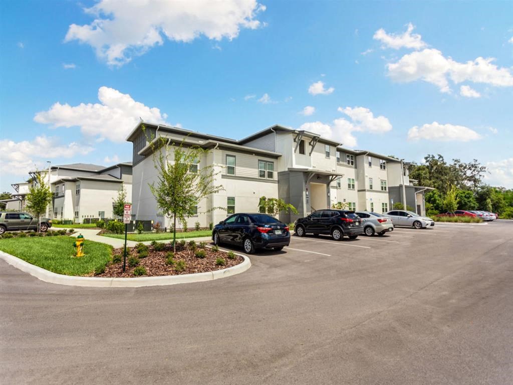 a parking lot with cars in front of an apartment building