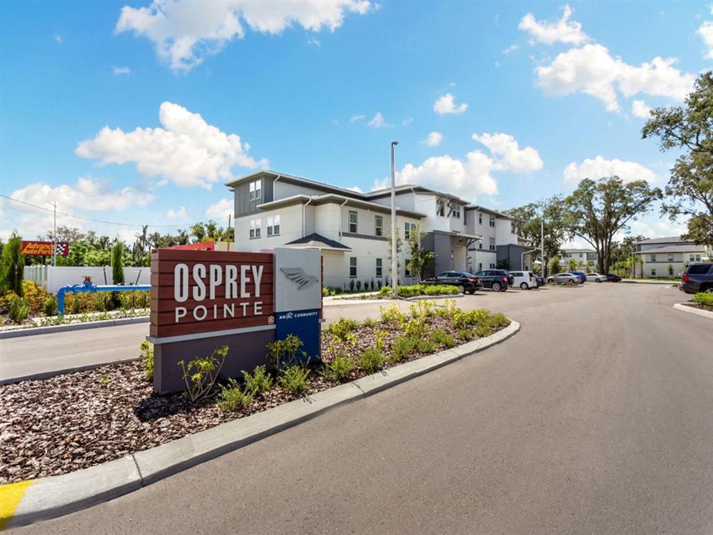 a sign that reads odyssey pointe on the side of a road