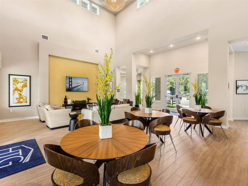 a dining room with tables and chairs and a living room