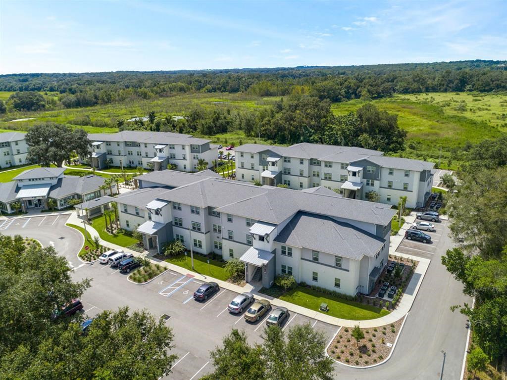 an aerial view of multiple apartment buildings with a field in the background
