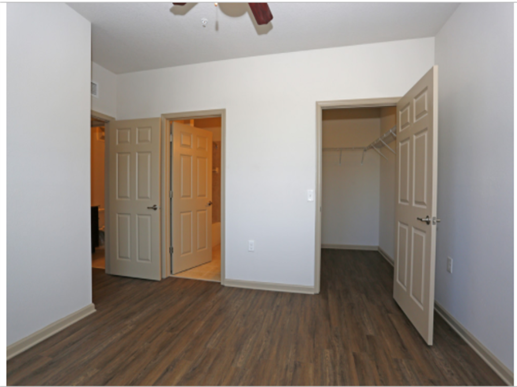 an empty room with two doors and a closet