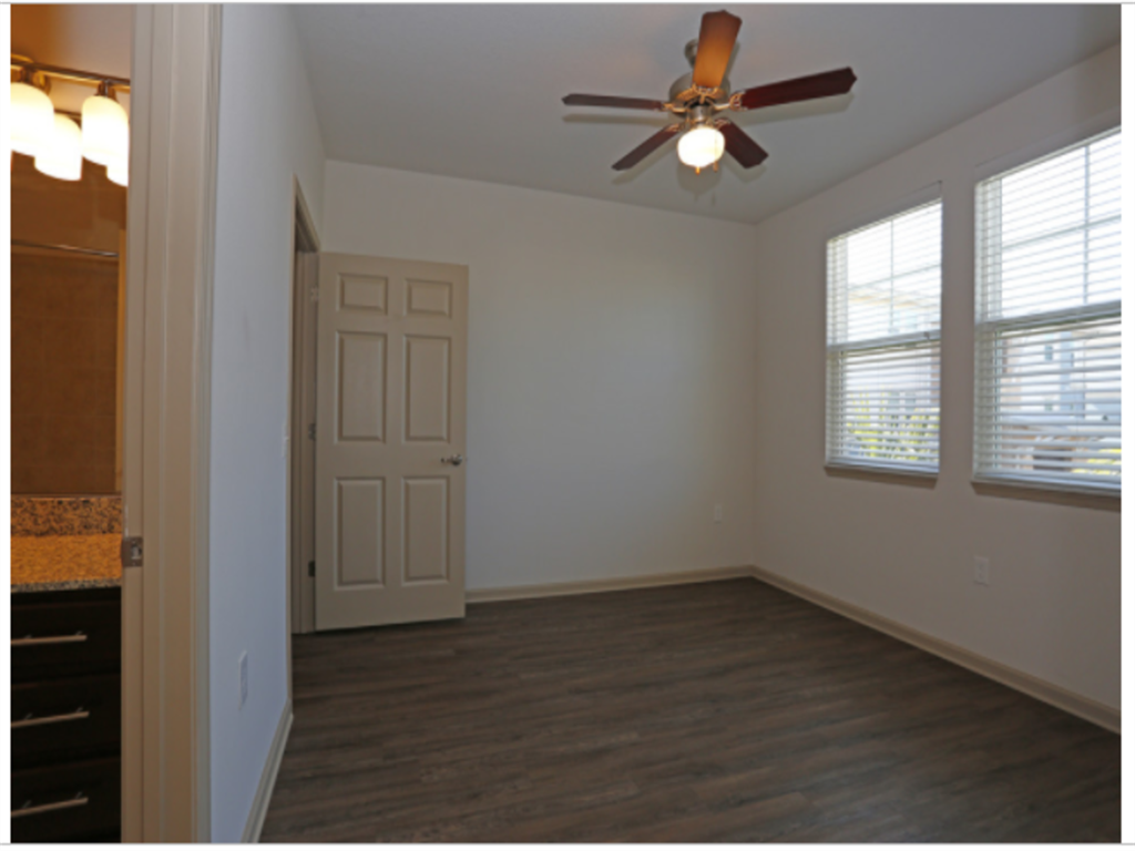 an empty bedroom with a ceiling fan and a closet