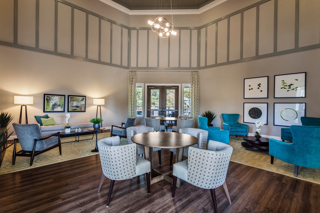 a living room with blue chairs and a round table