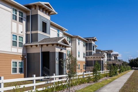 a row of town houses with a sidewalk in front of them
