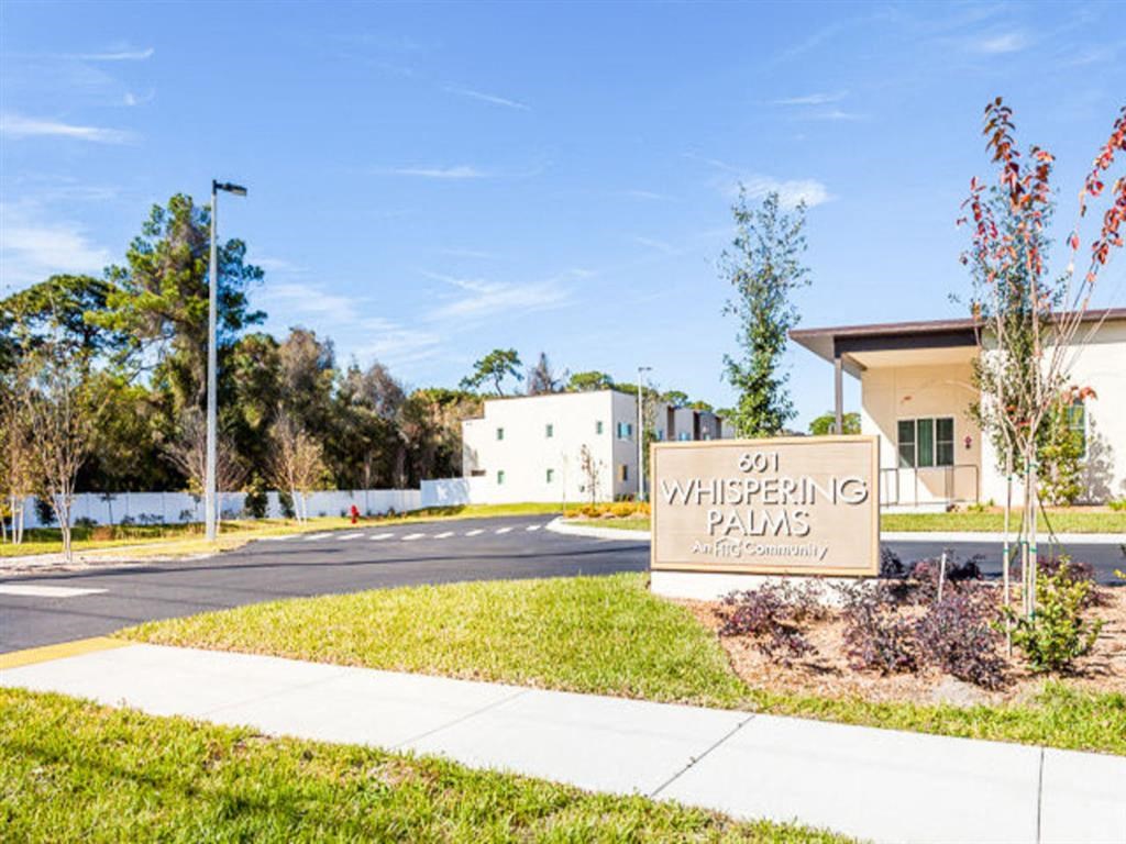 a building with a sign in front of it on a sidewalk