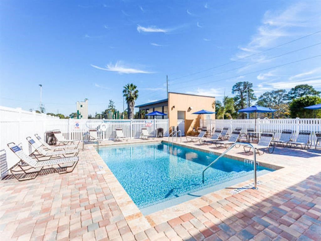 a swimming pool with lounge chairs and a building in the background